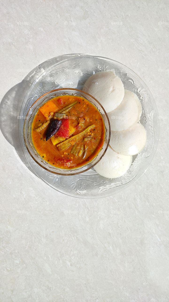 Beautiful White idlis with a medium spicy sambar, vegetarian breakfast from india