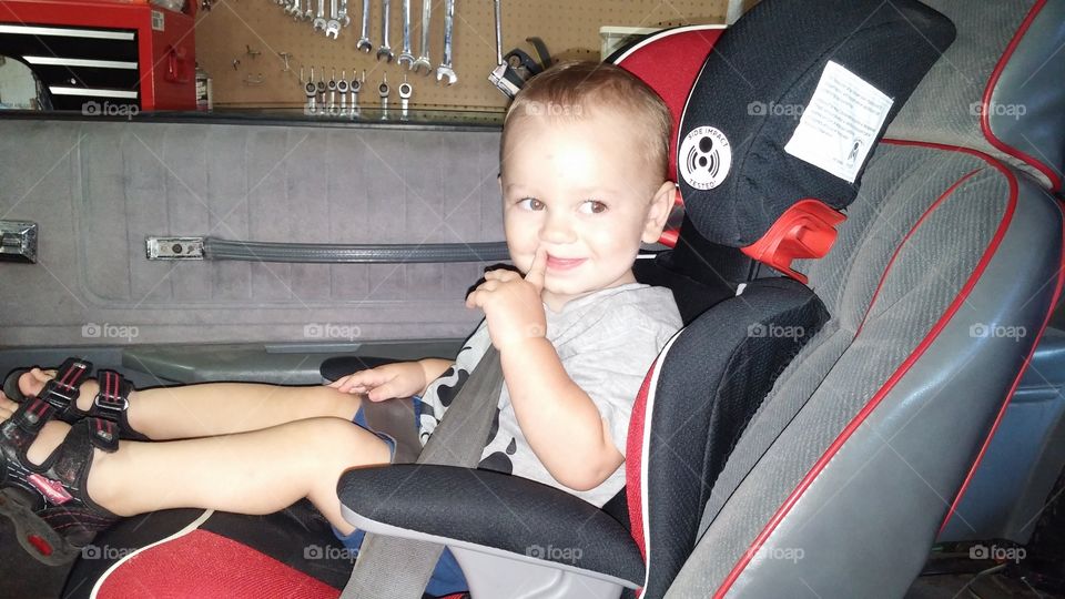 loving dadys car. he loves sitting in the car and being with dad working in the garage.