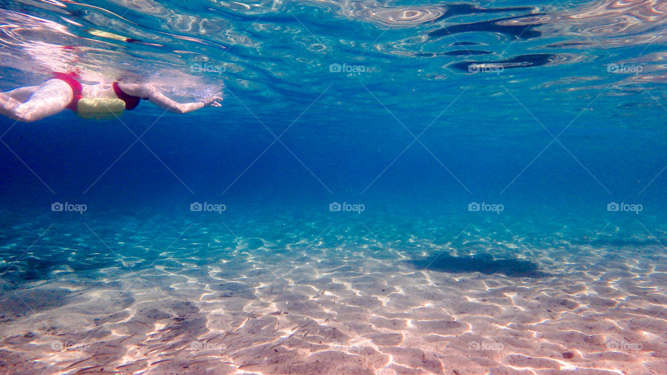 woman swiming on the sea surface, underwater photo