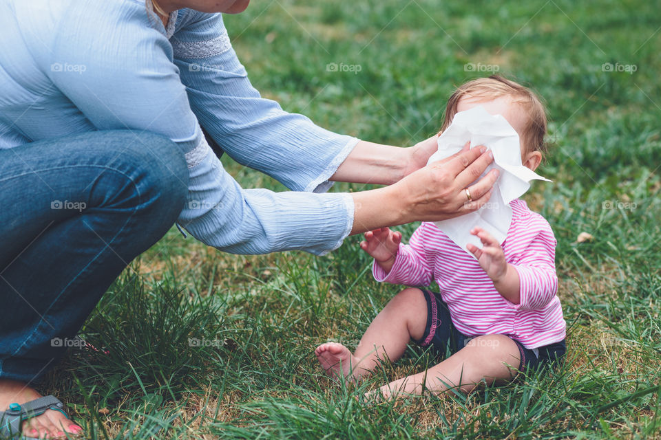 Mother wiping her sick baby's nose with tissue