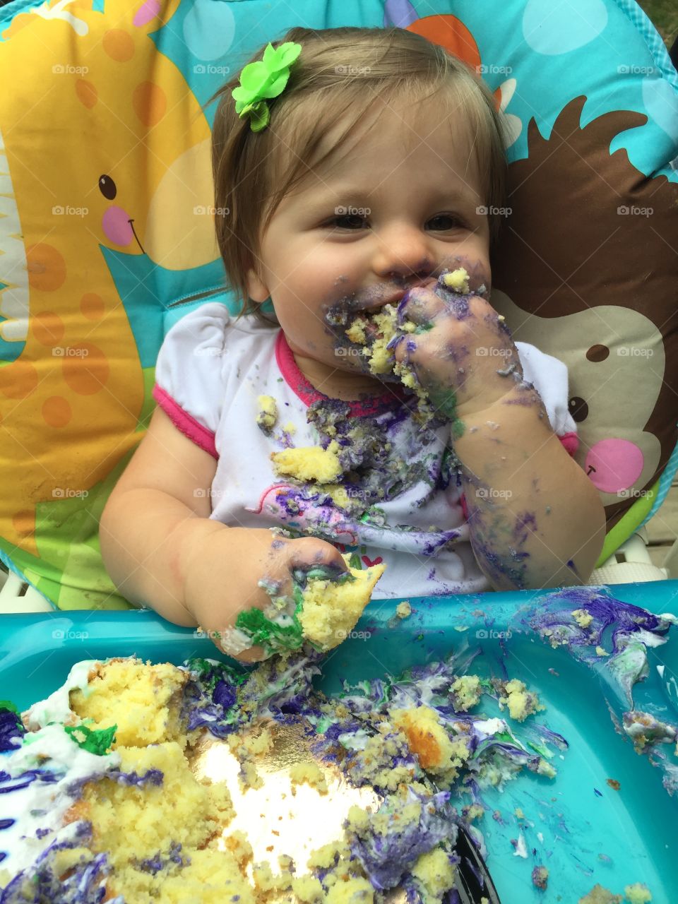 Adorable girl with messy face while eating cake