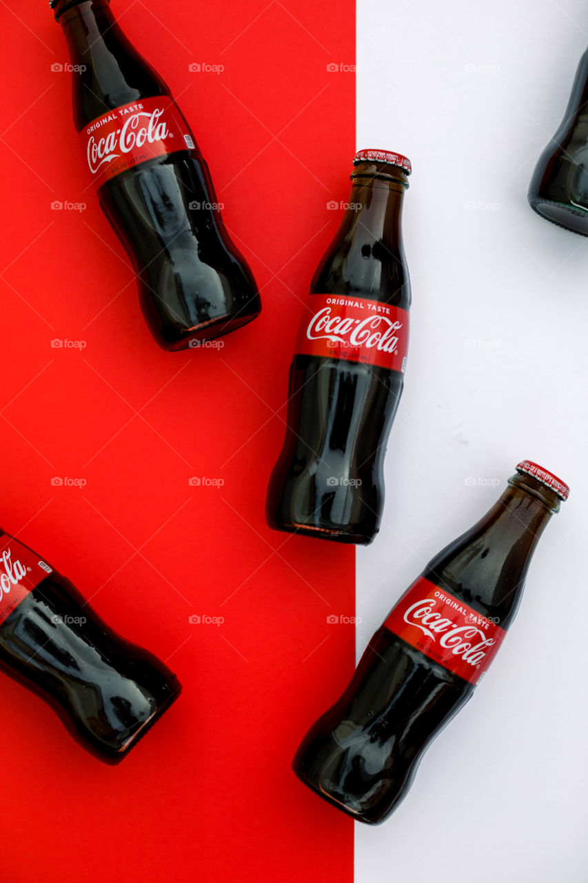 Coke bottles on white and red background 