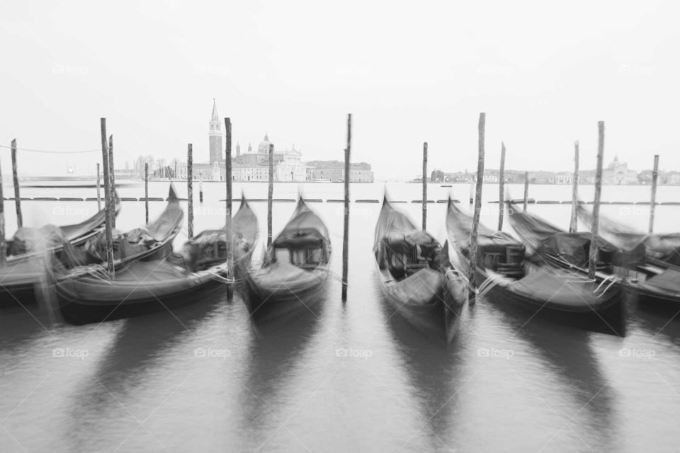 Long exposure of moored gondolas swaying placidly on a winter day.
