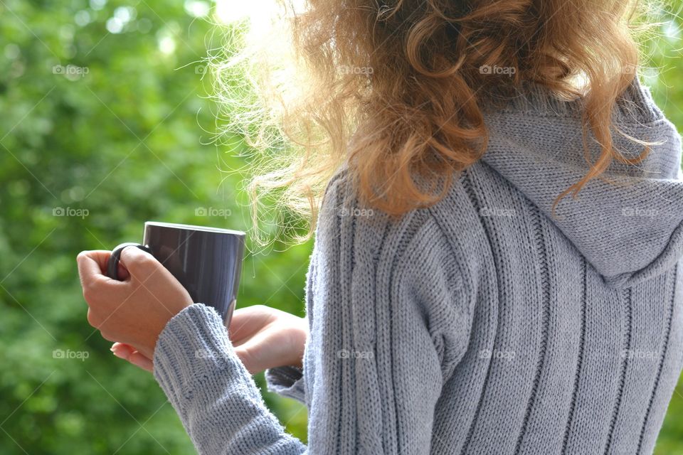 cup in the hands girl green summer background