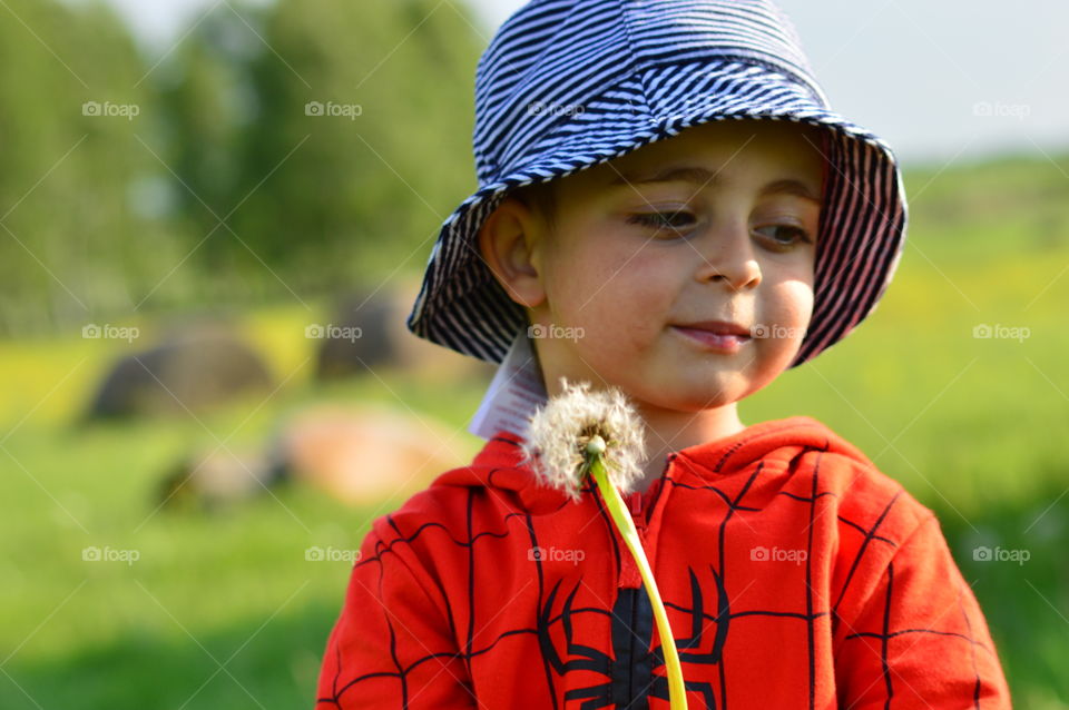 Boy standing with dandelion flower