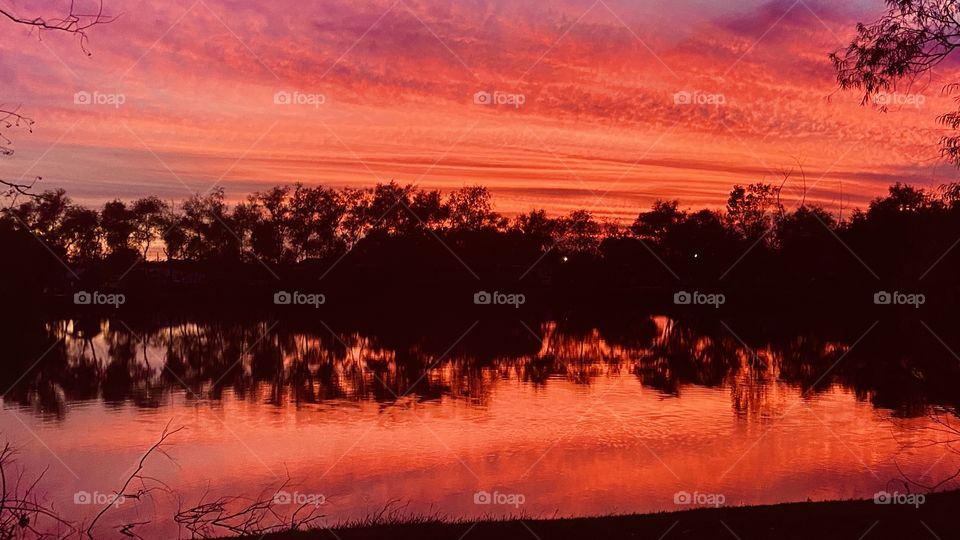 Fiery Red Sky at Night Sailors Delight. Total reflection of covered sky on the Lake Waters. 