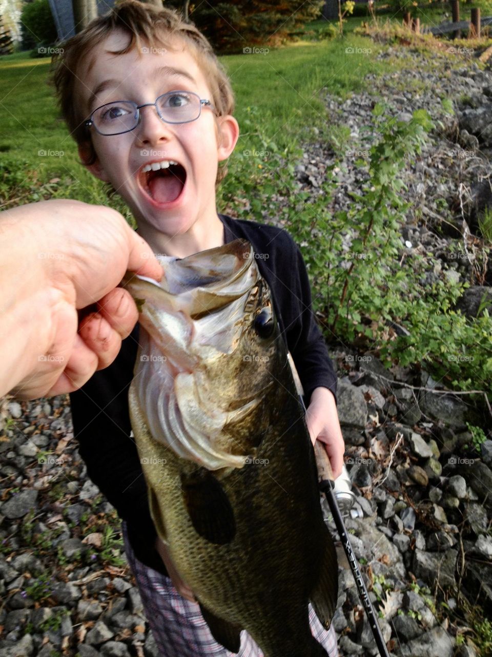 Young boy surprised at catching a nice smallmouth bass.