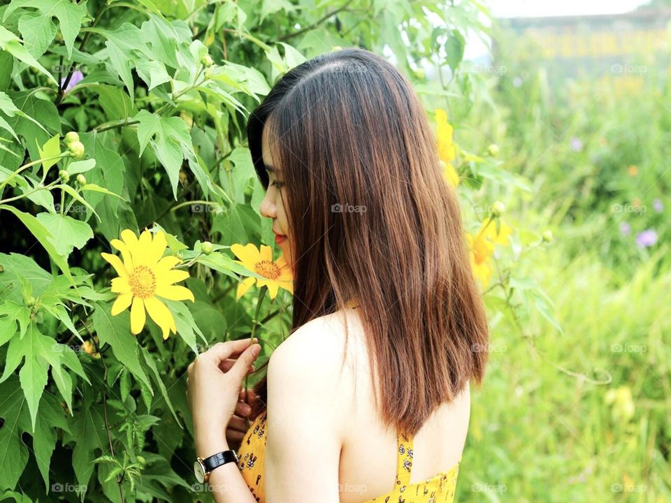 shy girl with flowers. The yellow color in the flower season is so beautiful!