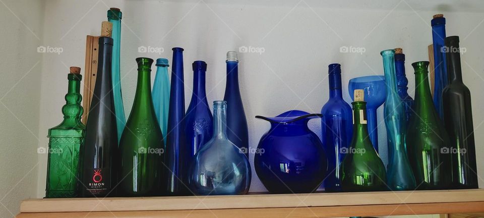 This beautiful glassware, bottles, vases and jars in all possible shades of indigo, blue and green are artfully presented here on a wooden shelf in the house in „Bavaria“, Germany that we have previously visited and adored. 2023. Hypnotic Productions