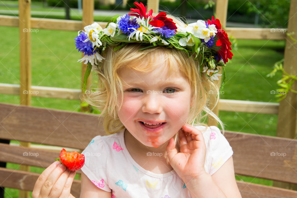 Portrait of a girl with crown eating strawberry