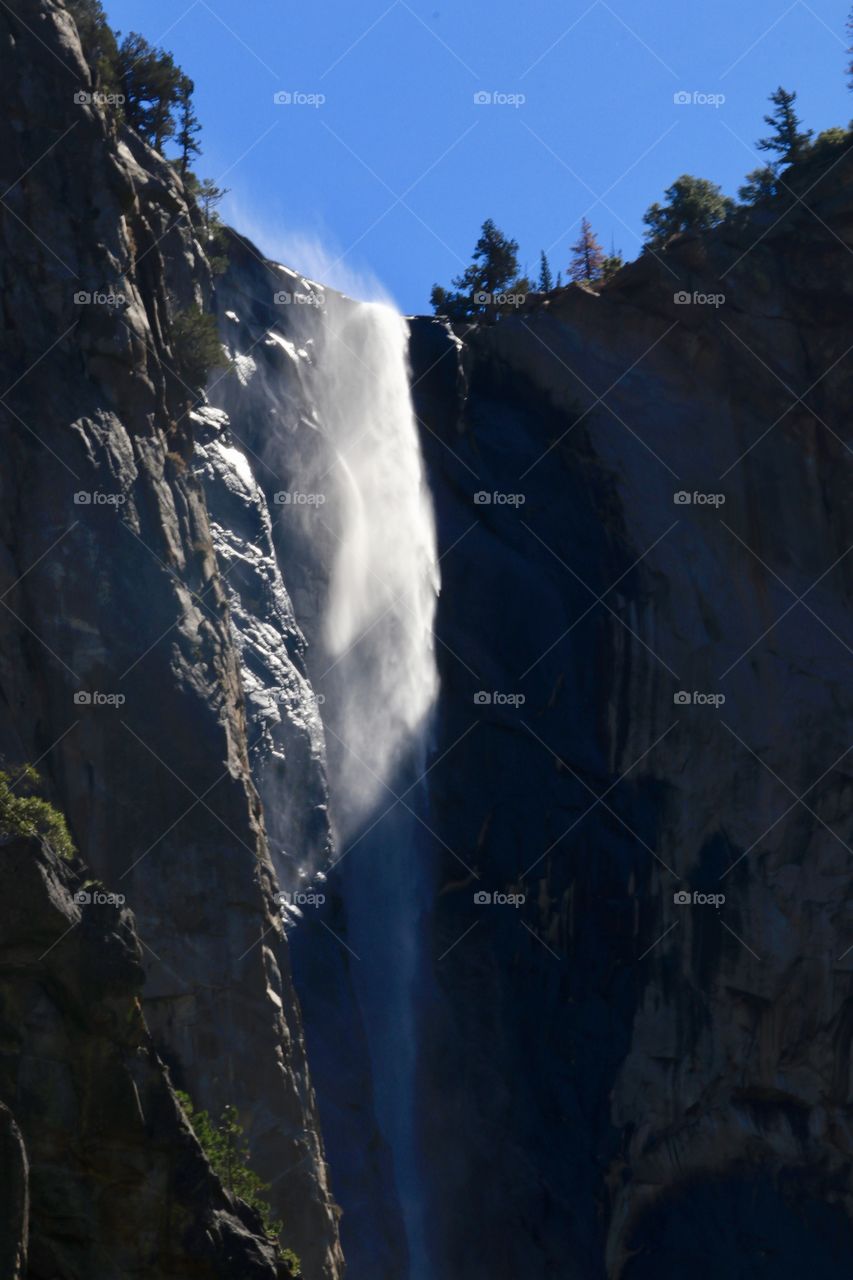 View from below vernal cascading rushing waterfall in Yosemite 