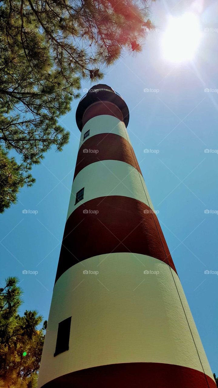 Sunbeams light up a lighthouse from the outside. Captured while looking skyward.
