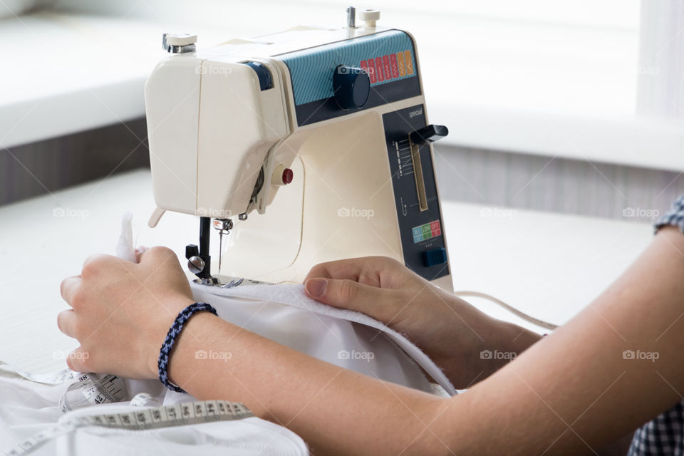 girl sews on the sewing machine