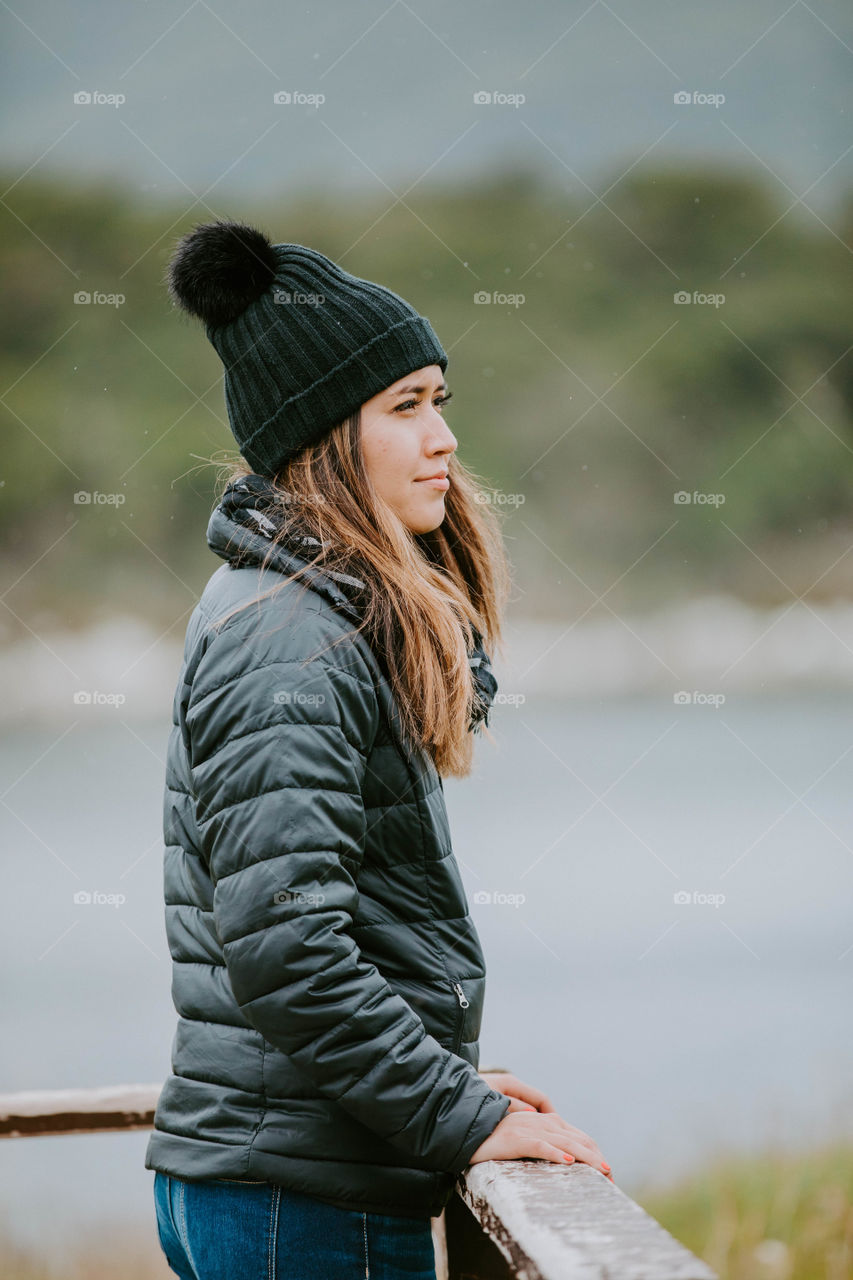 Girl wearing a black jacket and beanie on a rainy day 