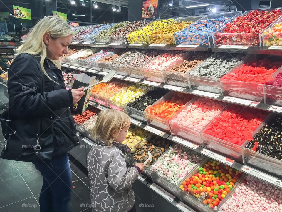 Mother and doughter buy sweets in local store in Sweden.