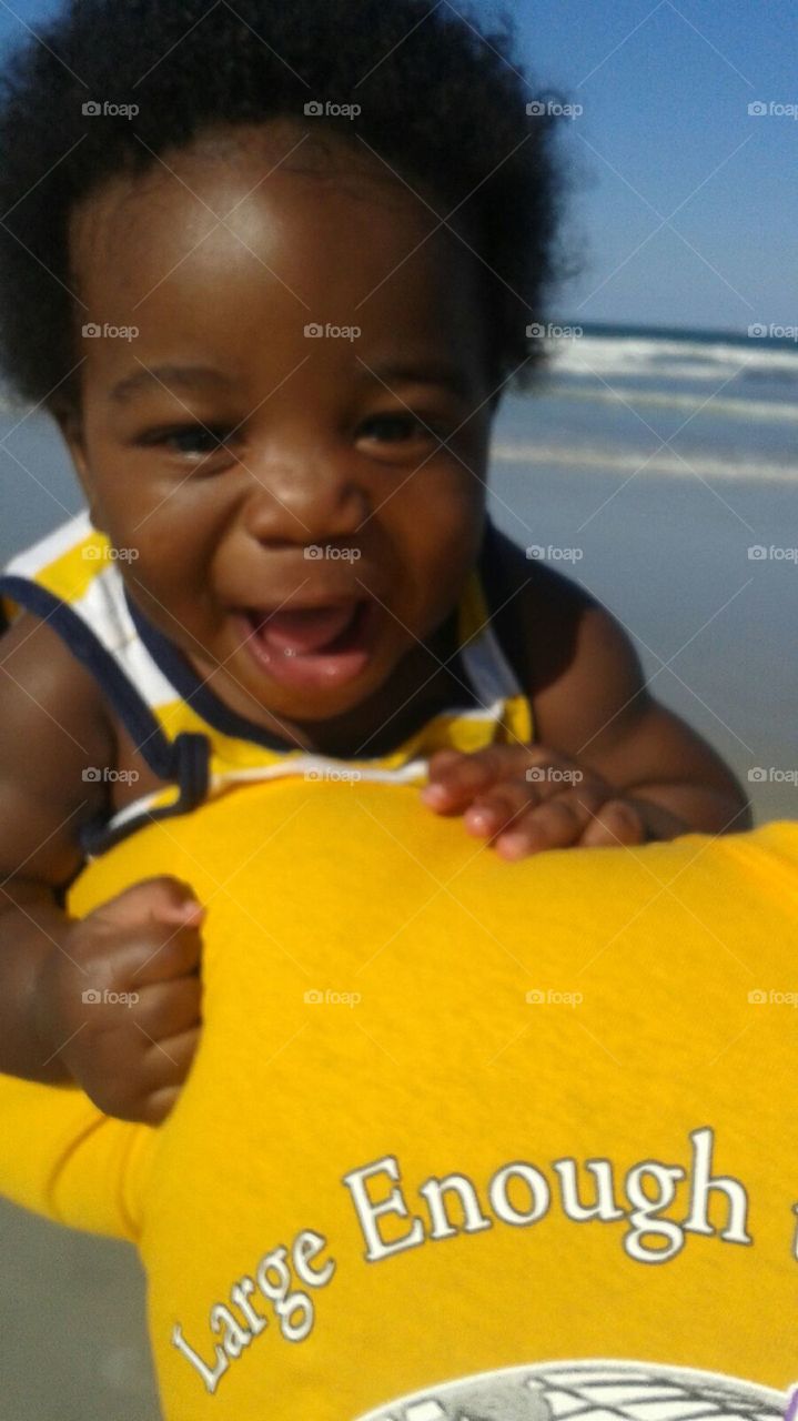 Excited baby on the beach . Baby's first trip to the beach