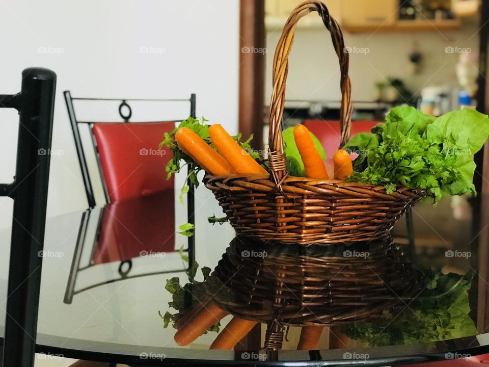 Eco friendly reusable wooden basket with full of vegetables on the dining table.