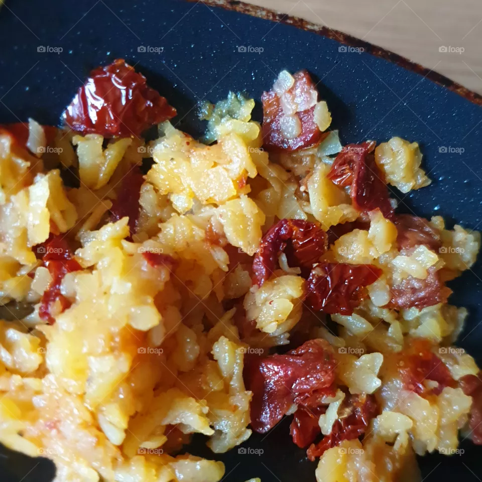 Rösti (potato dish) with sun-dried tomatoes in a pan.