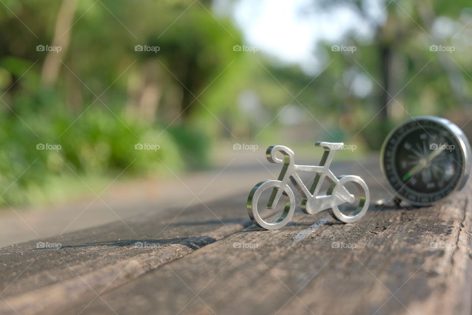 Tiny bicycle on wooden bench with compass