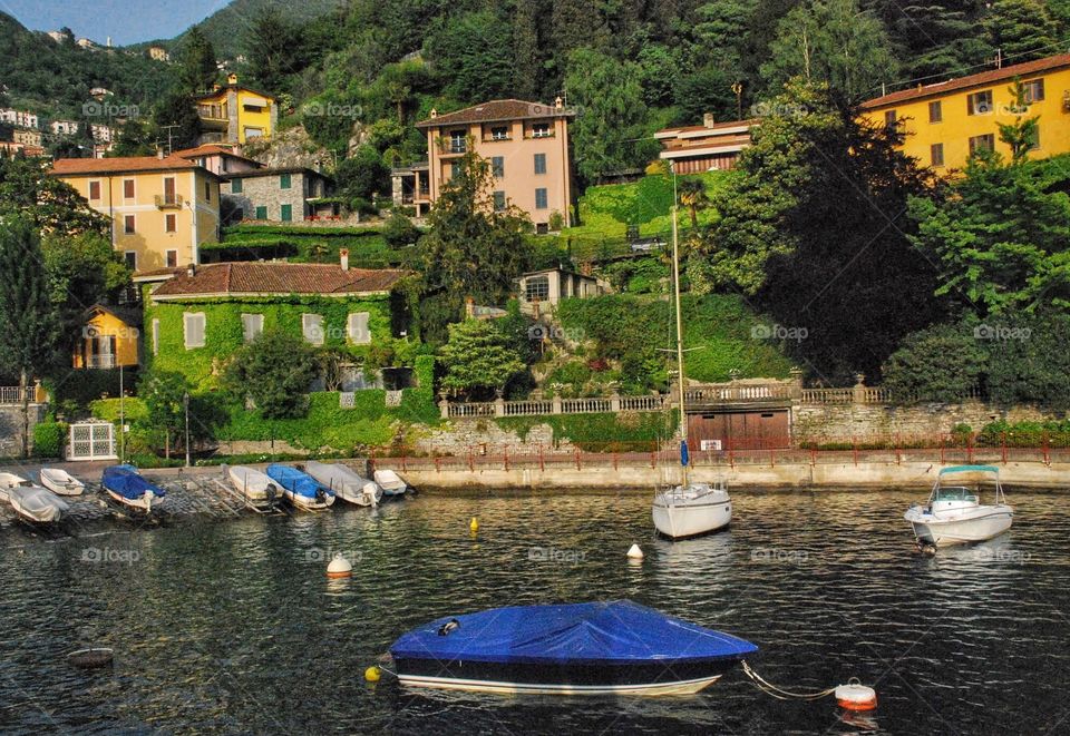 Blue beauty on the lake. Blue tarped boat moored on Lake Como