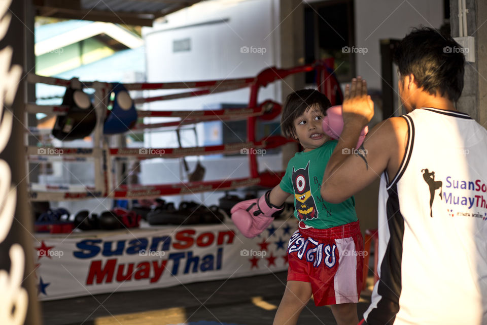 Kid punching trainer. Thithi training muyai Thai