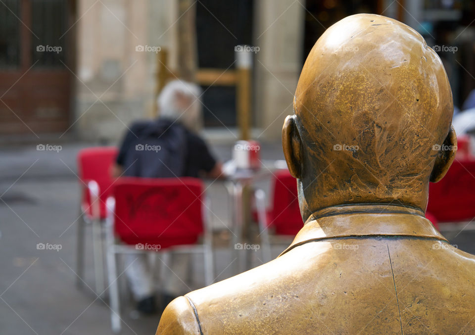 Elderly man looked by an elderly man sculpture