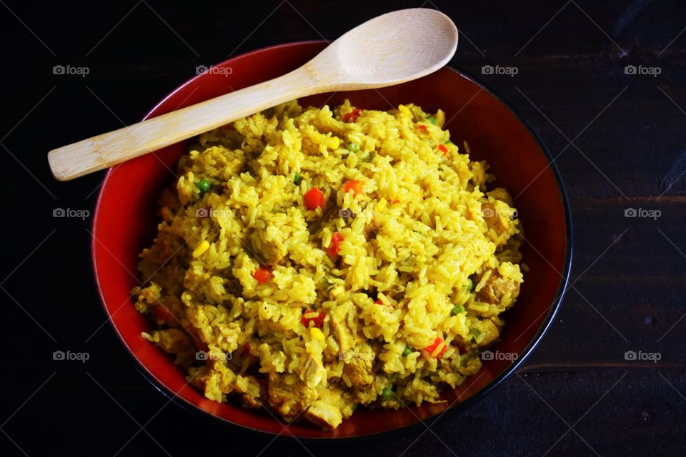 Bowl of Cuban yellow rice with a wooden spoon