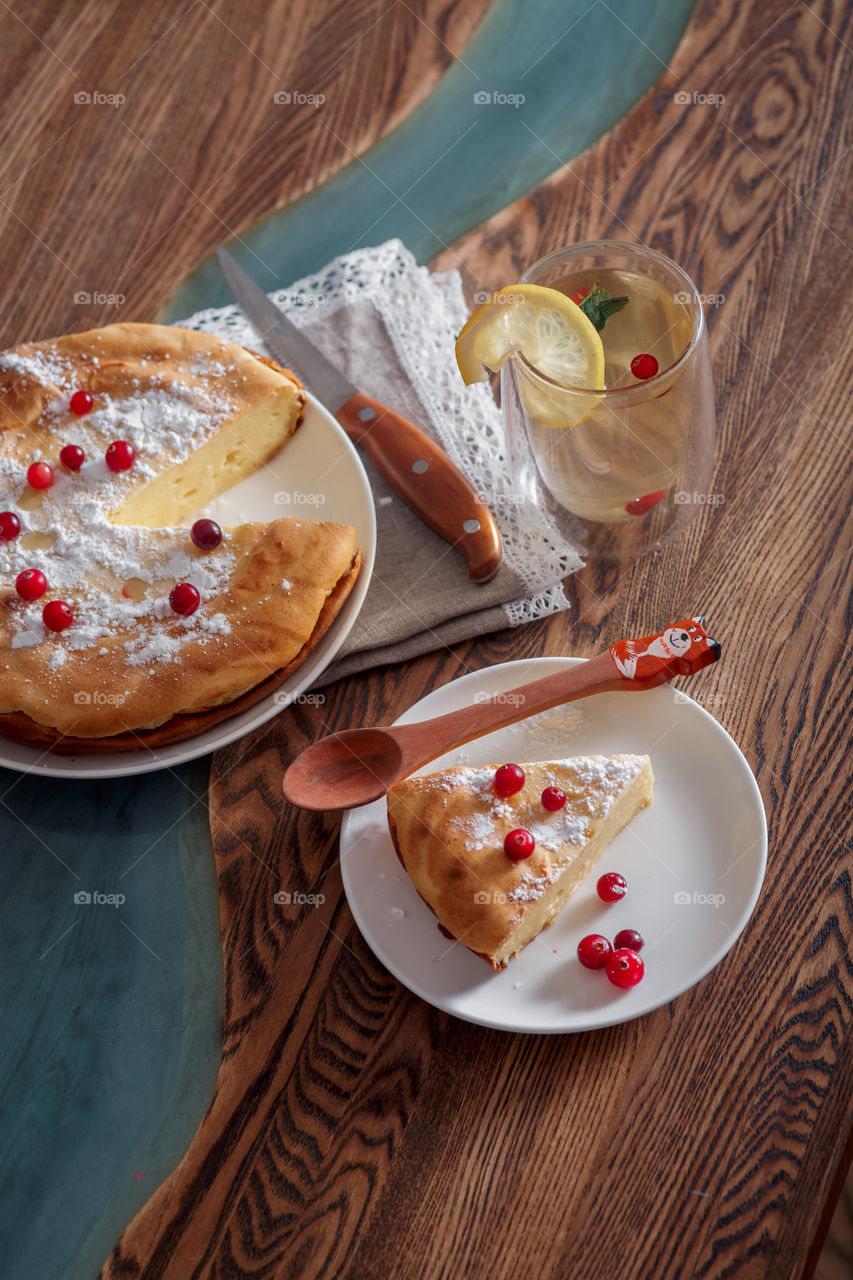 Cheesecake with cranberries and sugar on wooden background