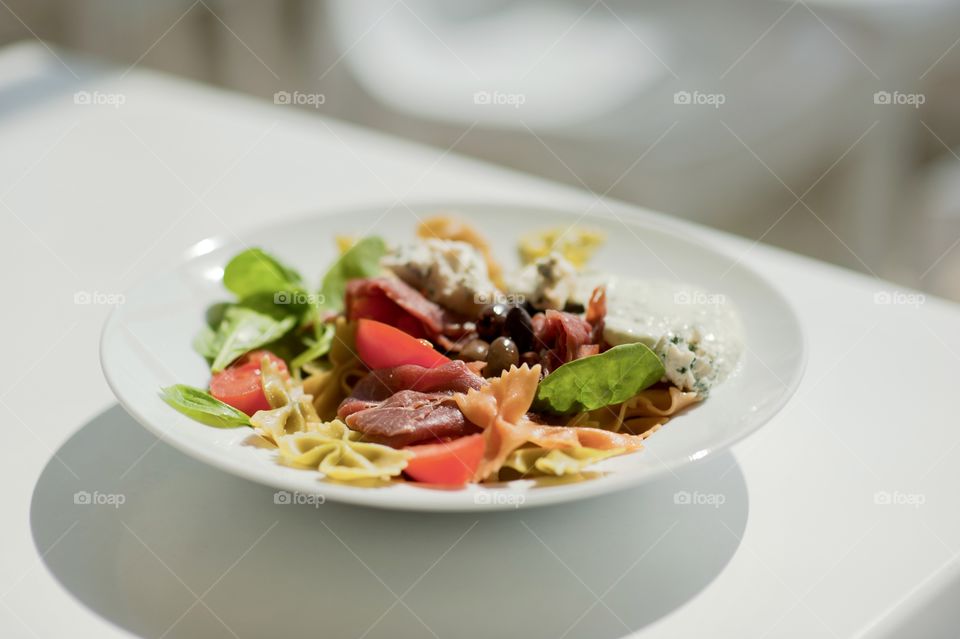 close-up of a young man eating a salad in a light kitchen