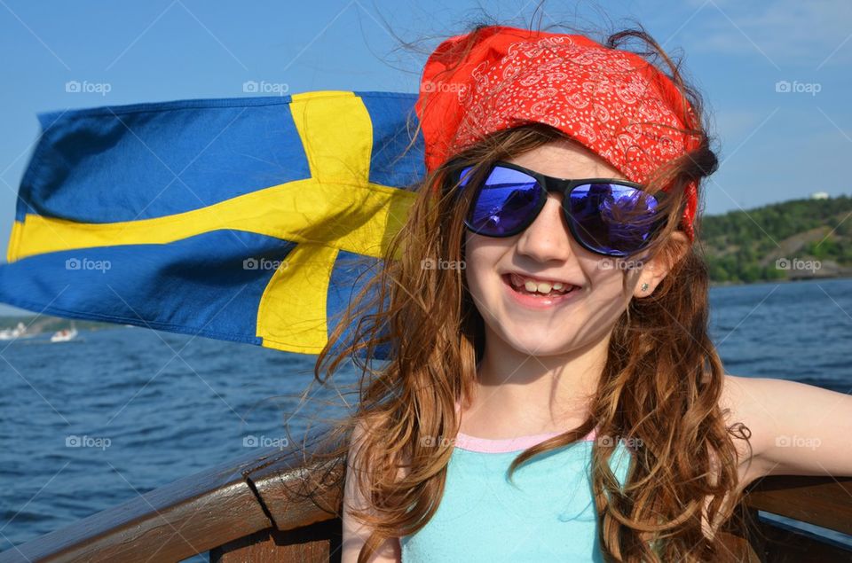 Baby girl on a motor boat with large sunglasses in Sweden