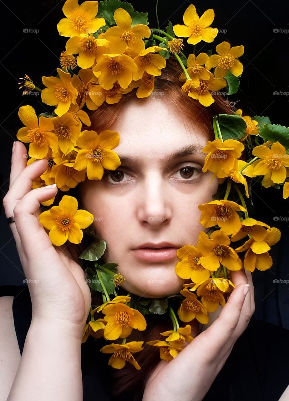 portrait of a girl with spring yellow flowers near her face
