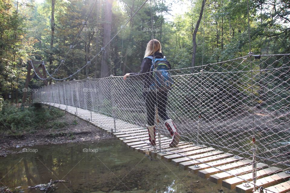 Woman hiking on bridge with back pack