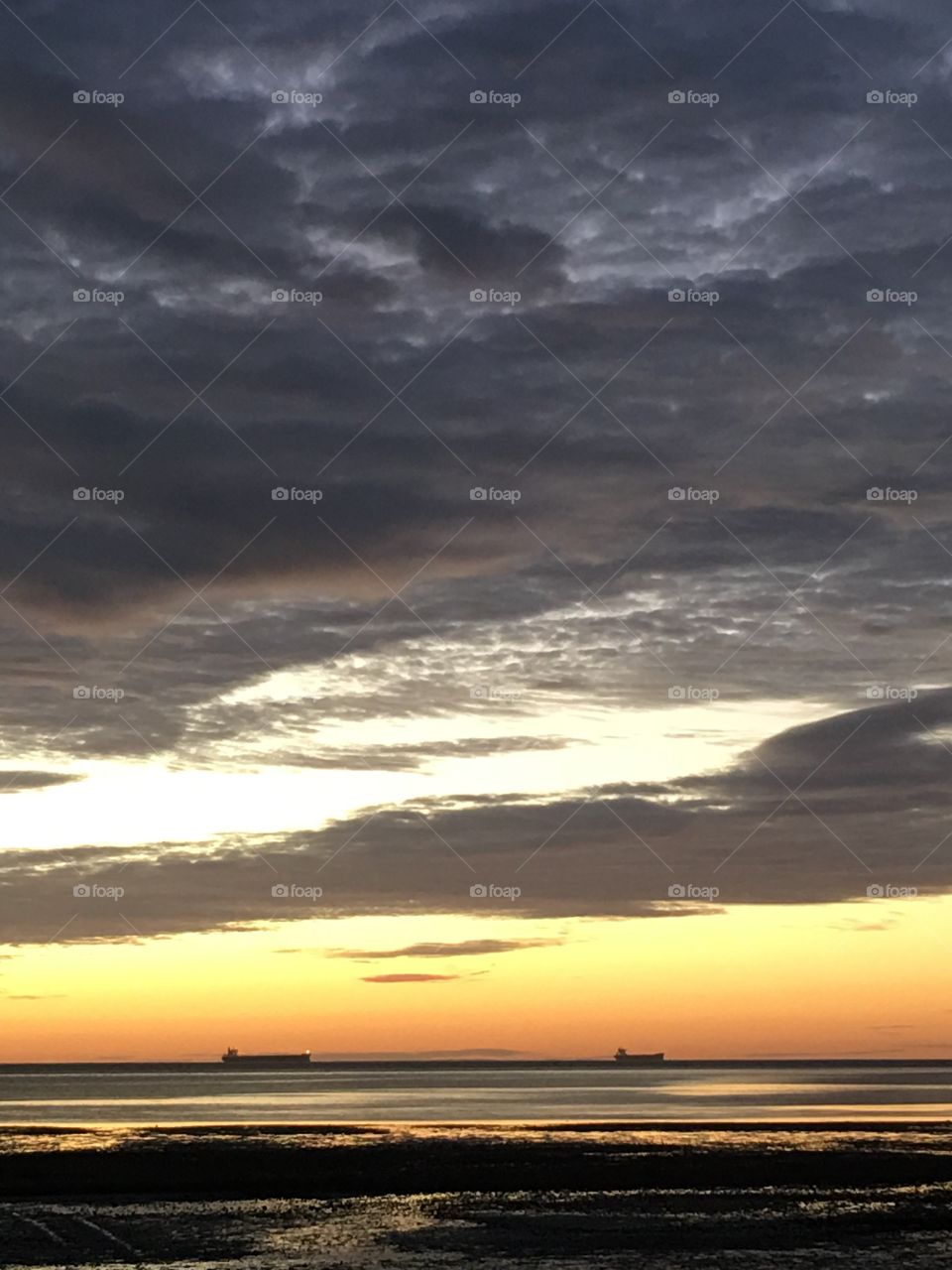 Morning Storm approaching with  ships in distance dark clouds at sunrise 