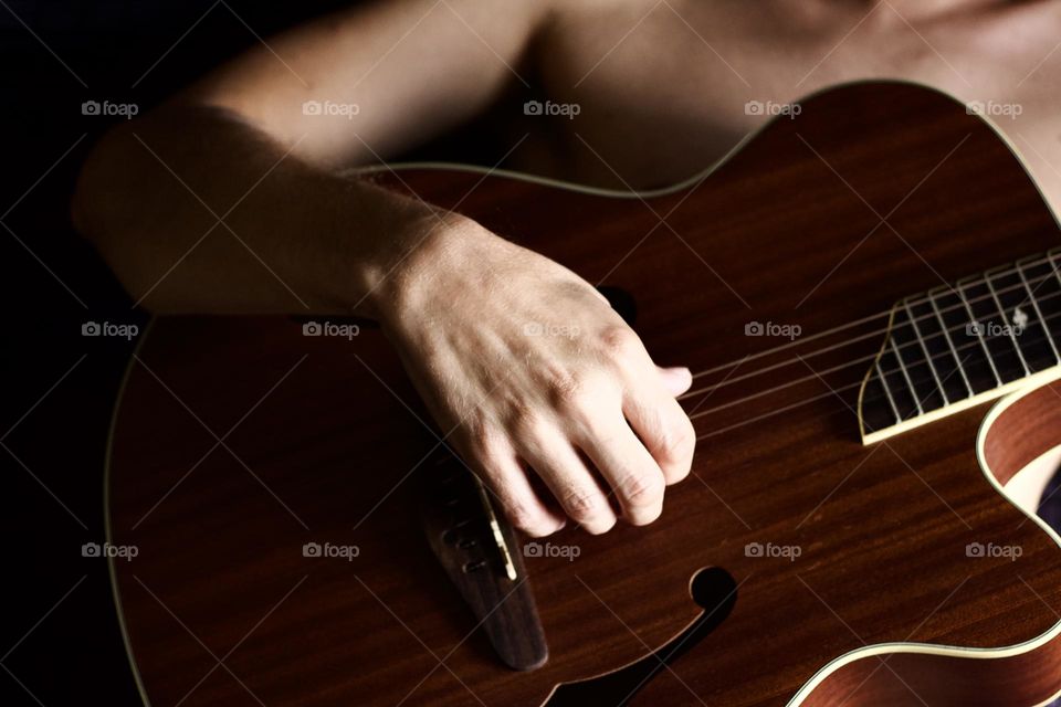 Man playing guitar in his bedroom