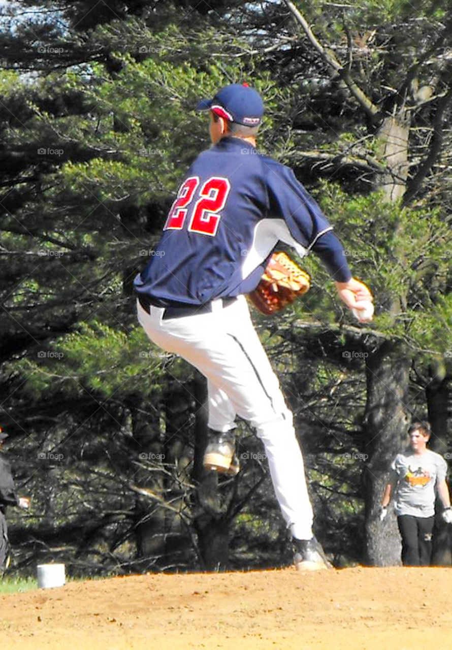 On the mound. 648 baseball pitcher in the windup to throw a pitch