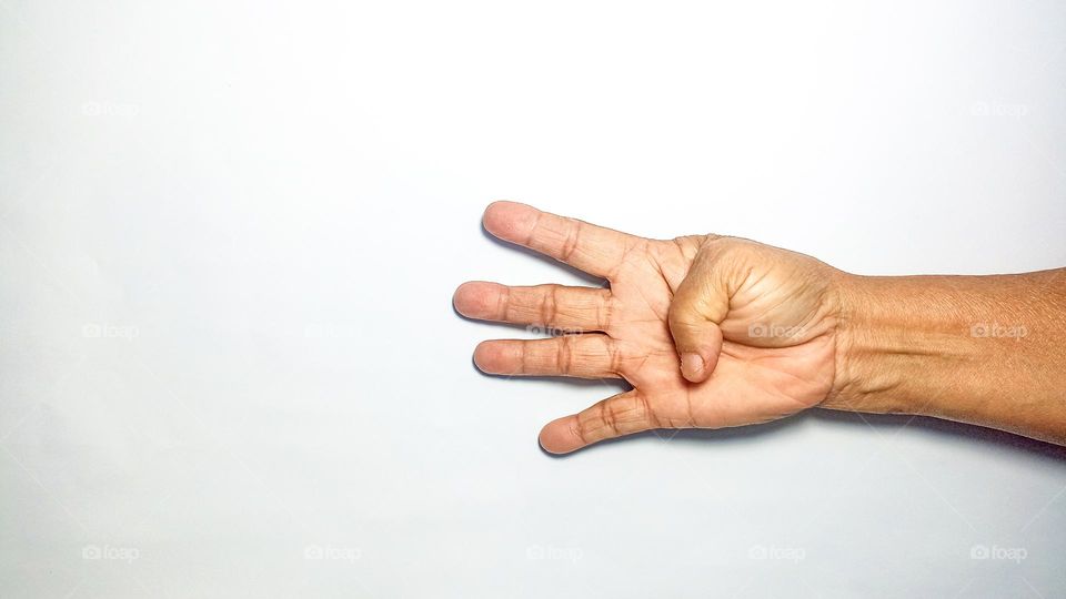 The palm is holding up four fingers in eye level view