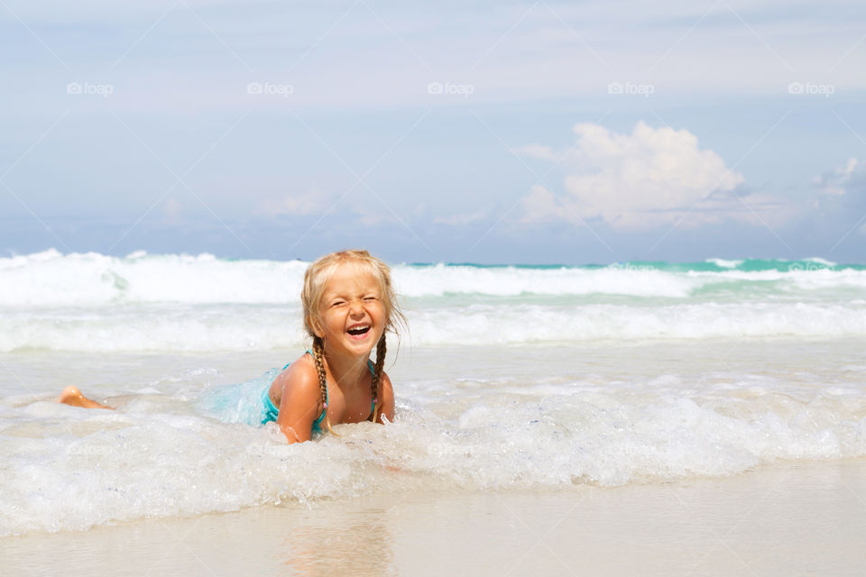 Happy little girl on the sea 