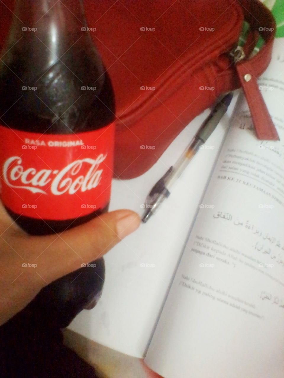 Learning accompanied by a small bottle of Coca-Cola in the palm of your hand