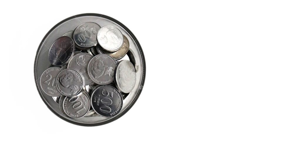 Photo of coins in a bowl on a white background