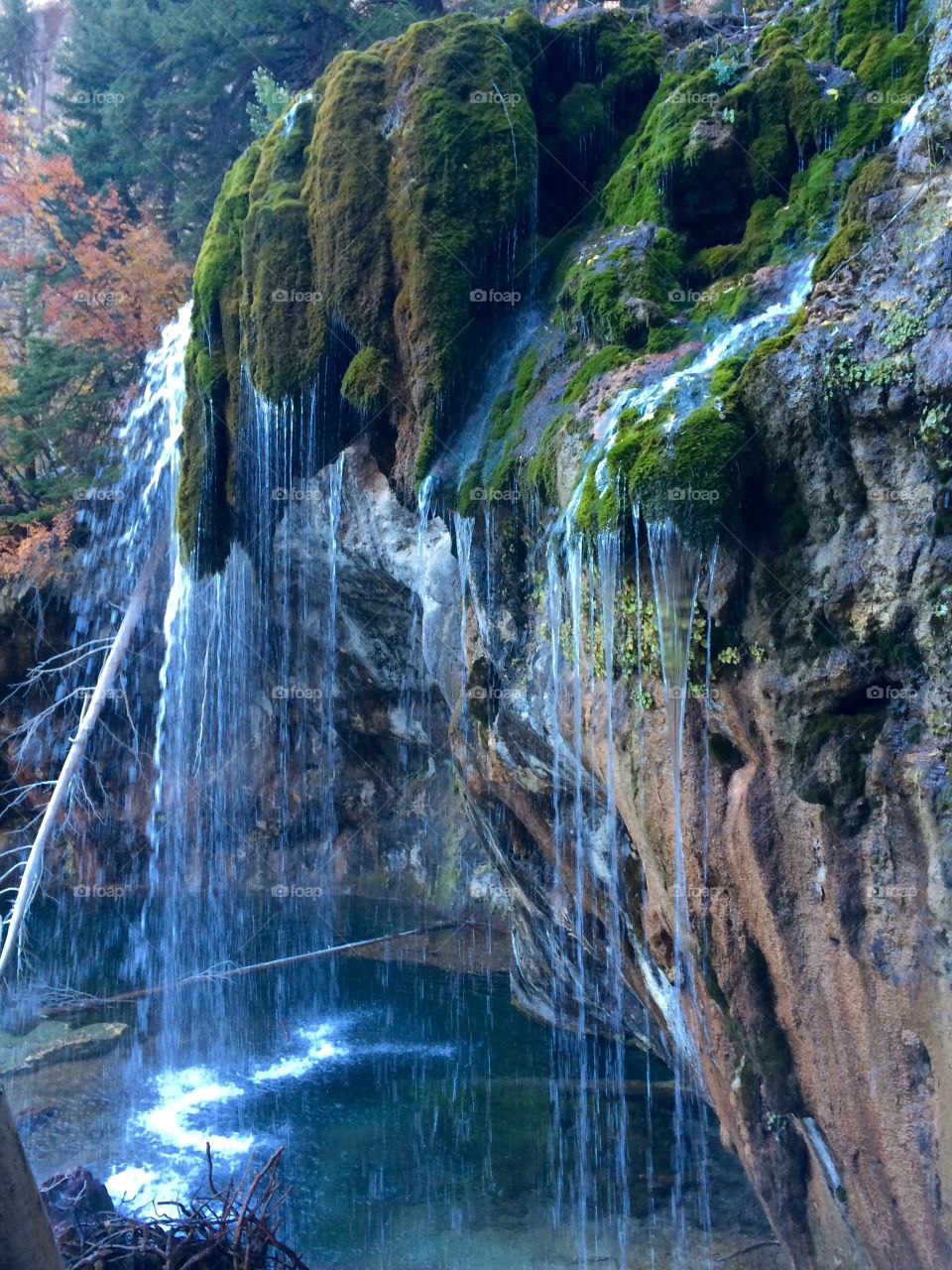 Waterfall falling from moss covered mountains