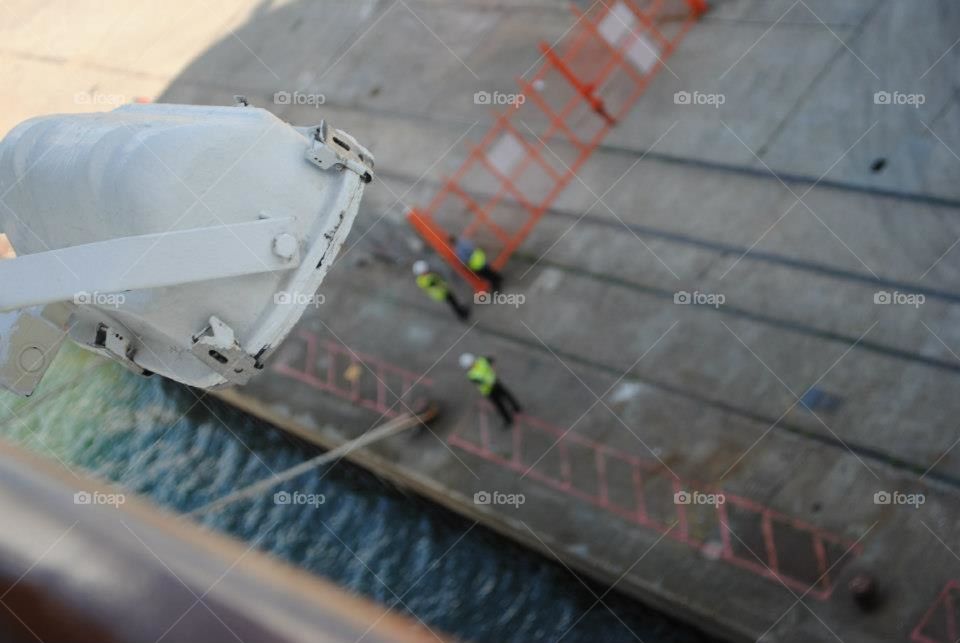 Dock workers working in a blurred background. 