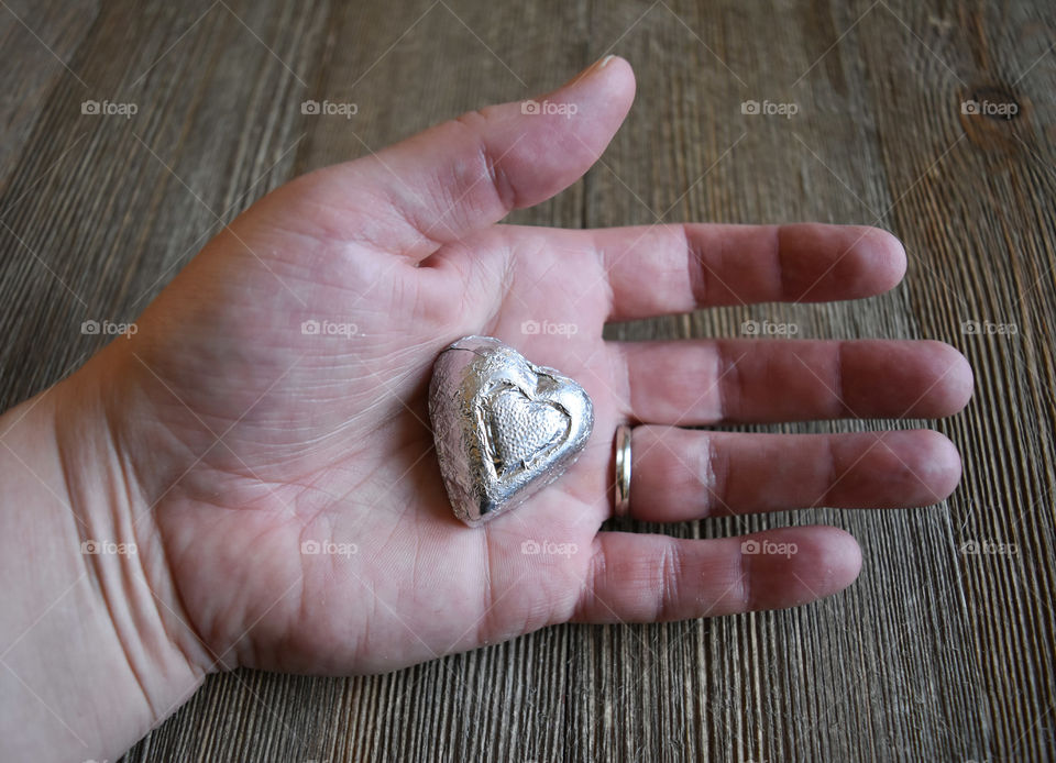 Hand holding heart shaped candy