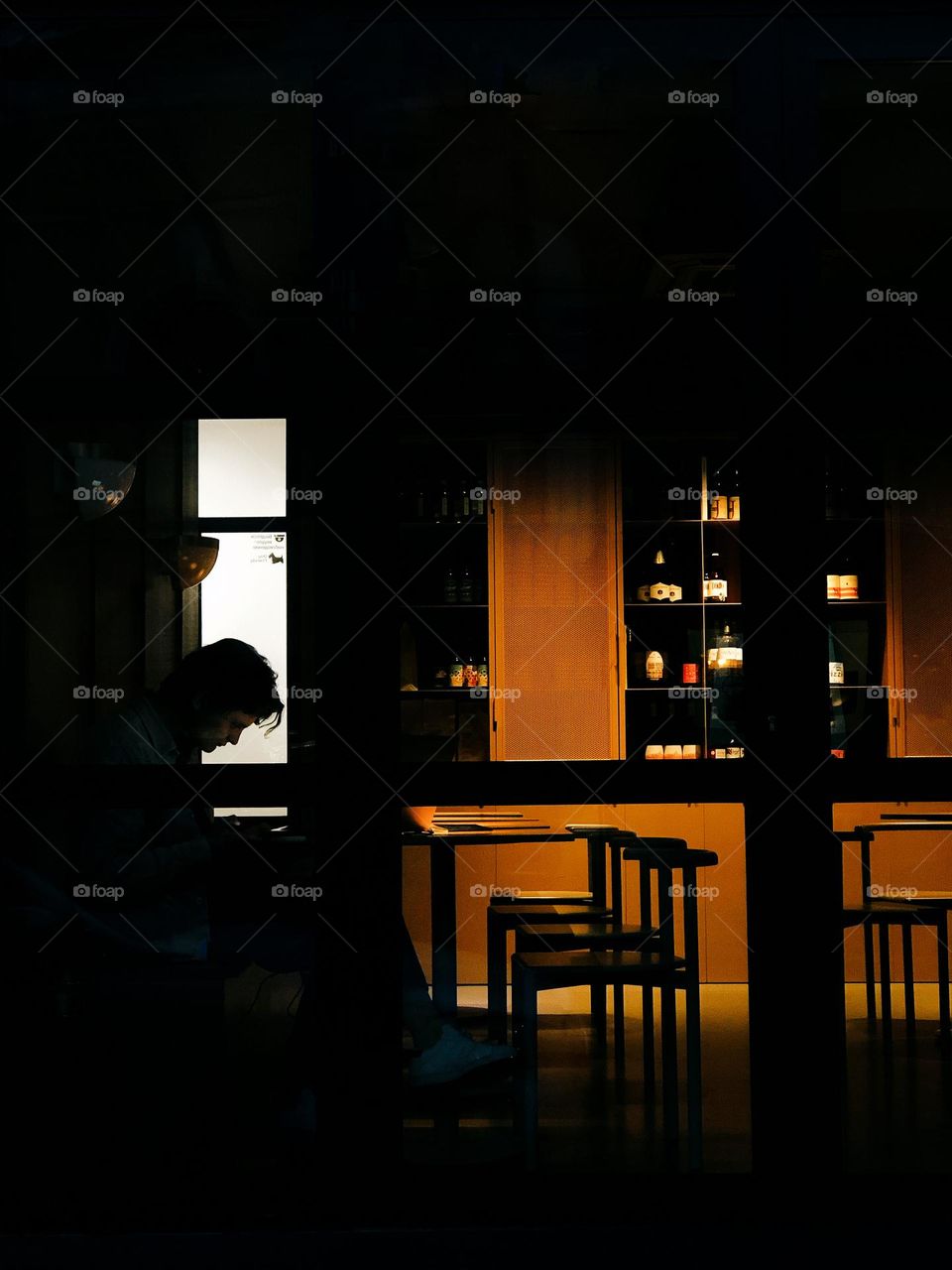 Silhouette of a young man in a cafe window 