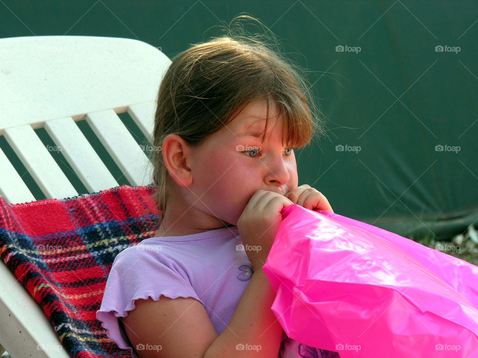 Close-up of a girl blowing inflatable balloon