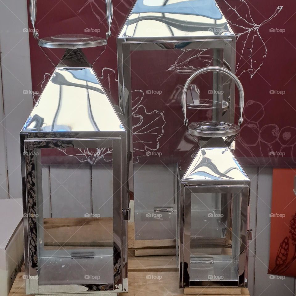 3 different size lamps for candles on shop display. shiney. glass