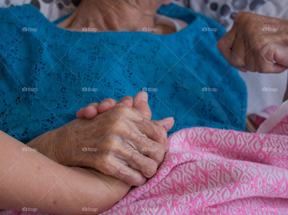 Person holding elderly's hand