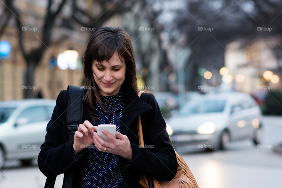 Beautiful woman using Smartphone on street