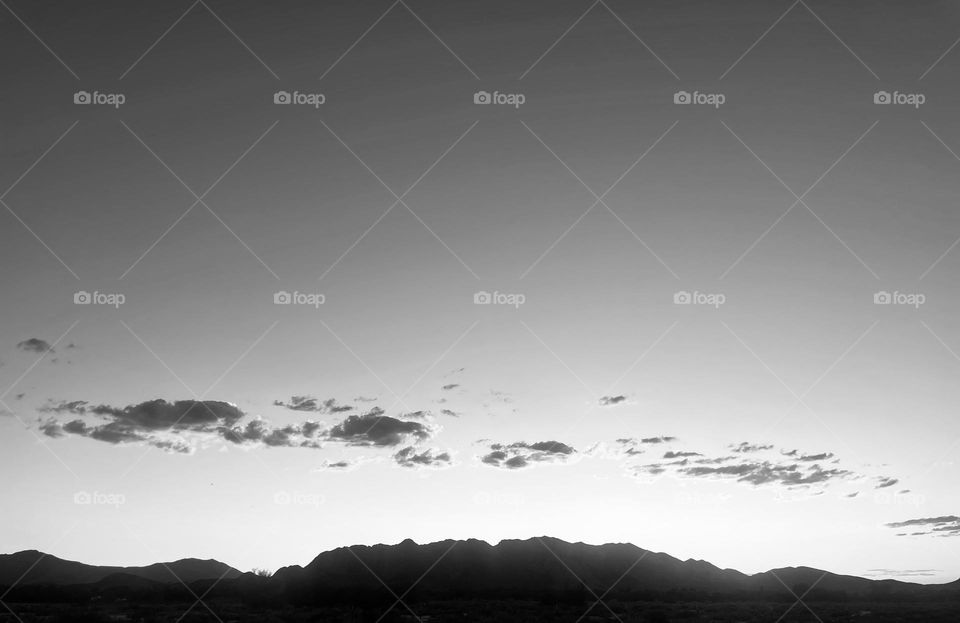 A black and white photo of mountains and clouds.  