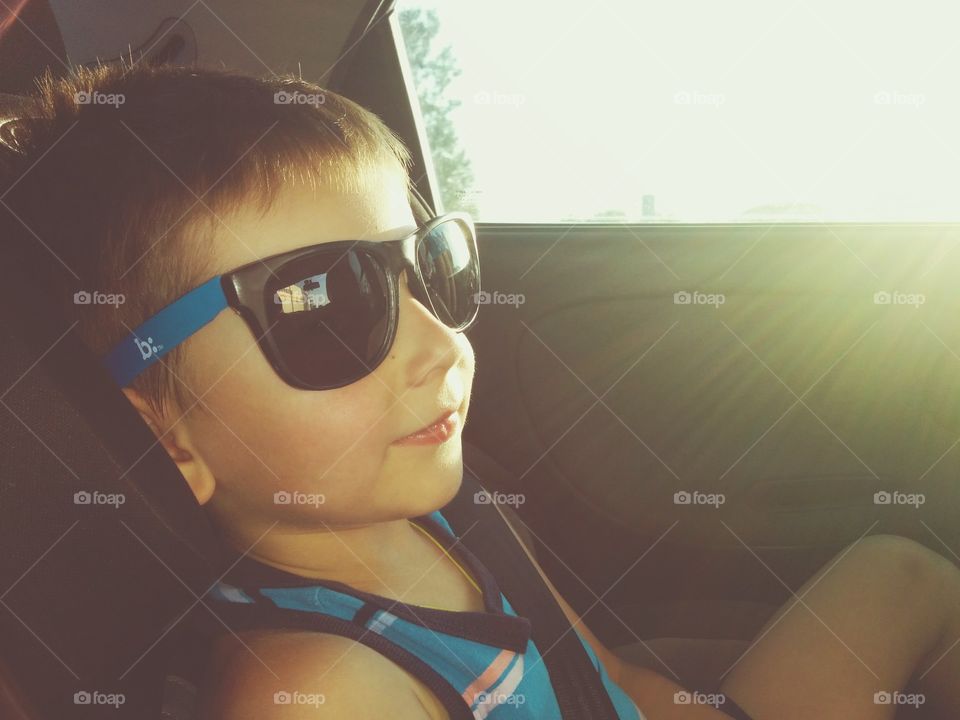 Boy with sunglasses. Boy with sunglasses into car