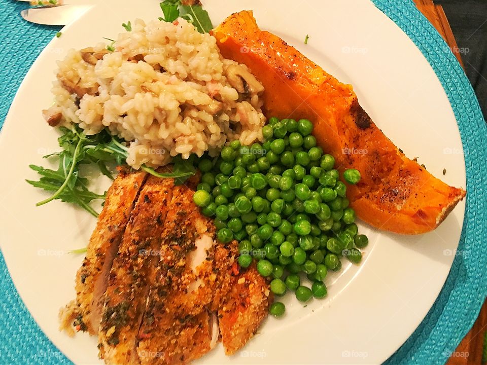 Mushroom risotto over arugula (rocket) and grilled chicken breast, with maple syrup glazed butternut squash pumpkin, and minted peas sides